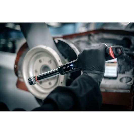 Facom E_516ST-340PB digital torque wrench used in automotive repair, close-up view with glove.