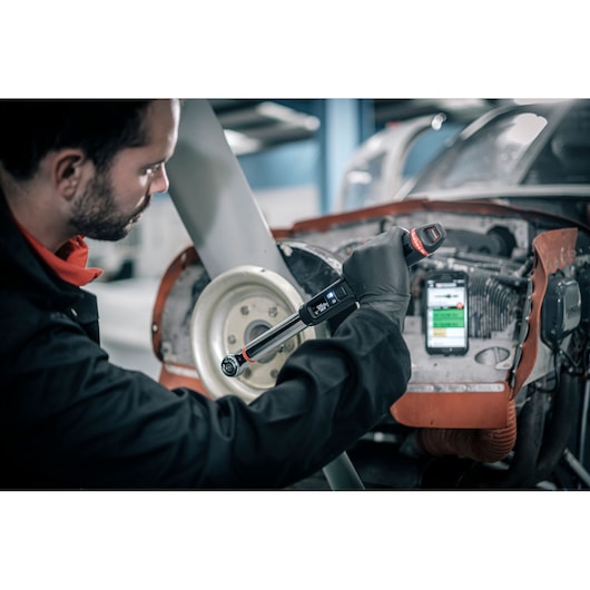 Facom E_516ST-340PB electronic torque wrench used by mechanic on vehicle engine in workshop.