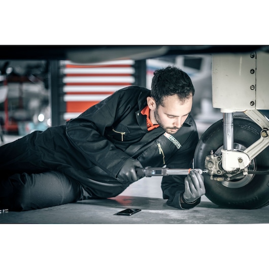 Facom E_516ST-340PB digital torque wrench used by technician adjusting aircraft landing gear.