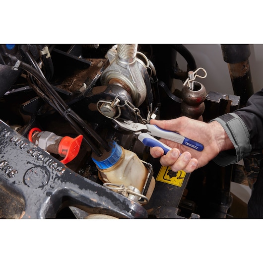 Facom E080503 pliers with blue handles in use on machinery, close-up photography.