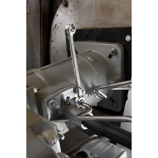 Photo of Facom E117388 combination wrench in use on a metal machine part.