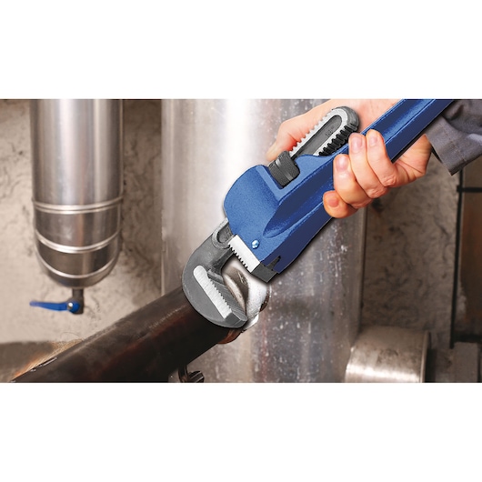 Facom E117825 pipe wrench in use tightening a metal pipe, close-up photo, blue handle.