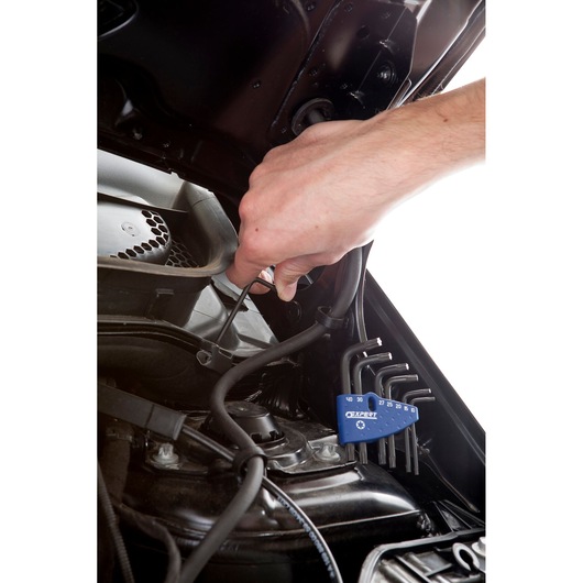 Facom E121103 hex key set used for automotive repair under car hood, angled view.