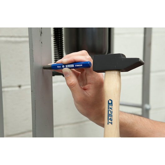 Facom E150501 blue punch used with a hammer to mark metal surface, close-up photography.