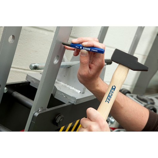 Facom E150501 hammer and punch tool used on a metal frame, close-up angle.
