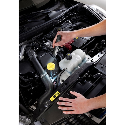 Facom E201406 inspection tool in use on car engine, photography showing tool held above open engine bay.