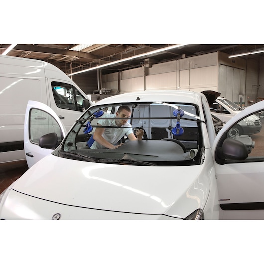 Facom E201501 automotive glass suction cup tool in use on car windshield, photographed in workshop setting.