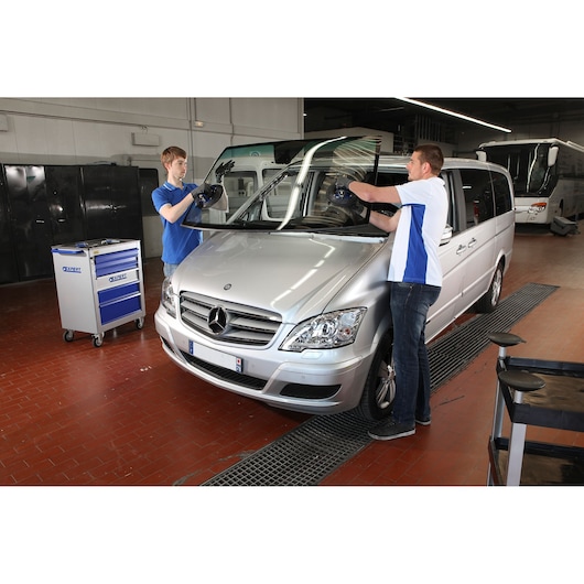 Facom E201504 photography of technicians replacing windshield on silver Mercedes van in workshop.