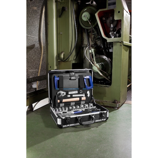 Facom E220109 tool kit with assorted hand tools in open case near industrial machine.