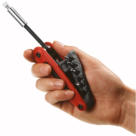 Facom EFPZ multi-bit screwdriver in hand, red handle, with bit holder, side angle, photography.