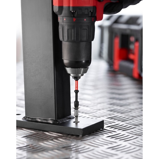 Facom EN_1J24PB screwdriver bit attached to a drill driving a screw into metal, side view, workshop setting.