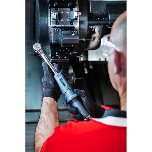 Photo of a worker using a Facom J.307-50D digital torque wrench on industrial machinery.