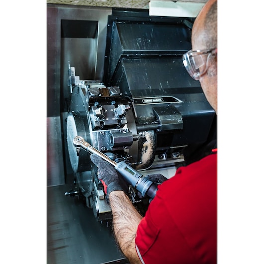 Photo of person using Facom J.307A50 digital torque wrench on industrial machinery.