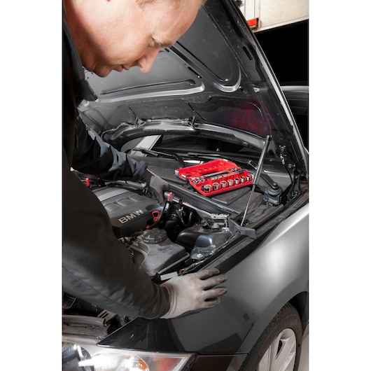 Facom JXL_DBOX1 socket set in red case on car engine, mechanic working, automotive photography.