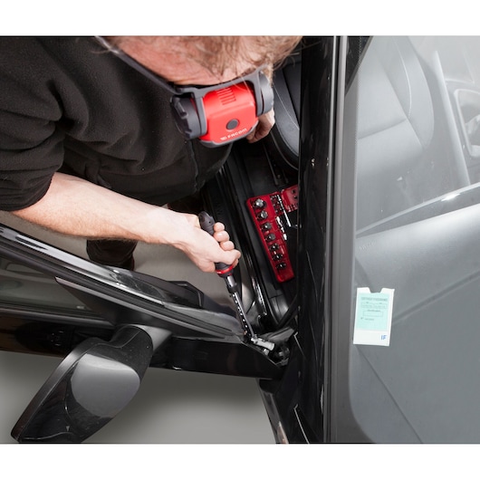 Photo of Facom JXL_DBOX1 mechanic screwdriver set in use for car door repair, top angle.