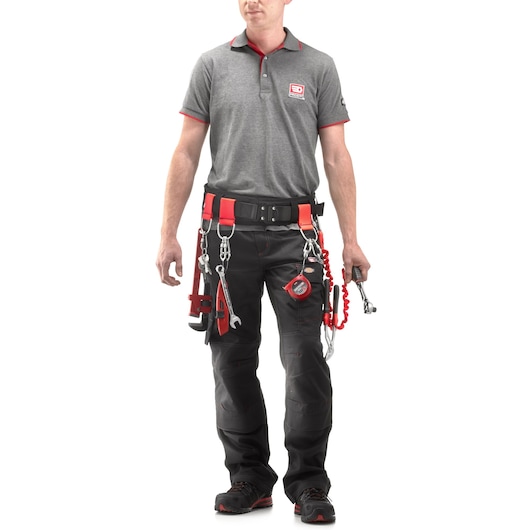 Facom MOUSQ6X60SLS photography of worker wearing grey polo and black tool belt with safety lanyards and tools, front view.