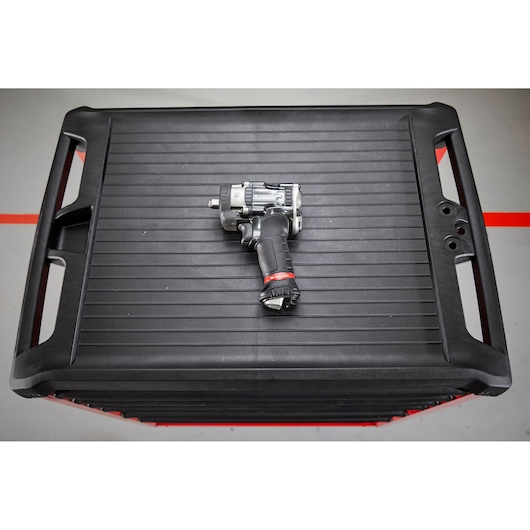 Facom NS.2500GPB impact wrench with black and red handle on a ribbed plastic tool chest, top view.