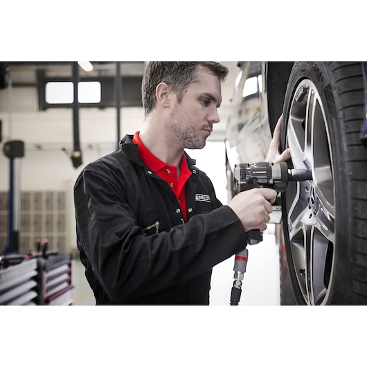 Facom NS.2500GPB photography of mechanic using impact wrench on car wheel in workshop.
