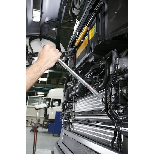 Facom R_248-25D torque wrench used on engine components in a workshop setting.