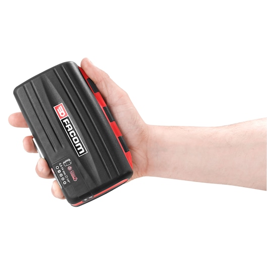 Photo of a Facom R_360NANO compact black and red tool case held in a hand, front angle on white background.