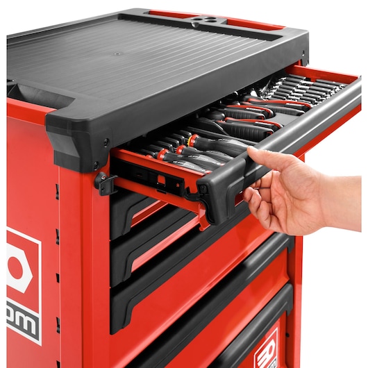 Facom ROLL.6M3A red tool chest with open drawer showing assorted hand tools, side view, hand opening drawer.