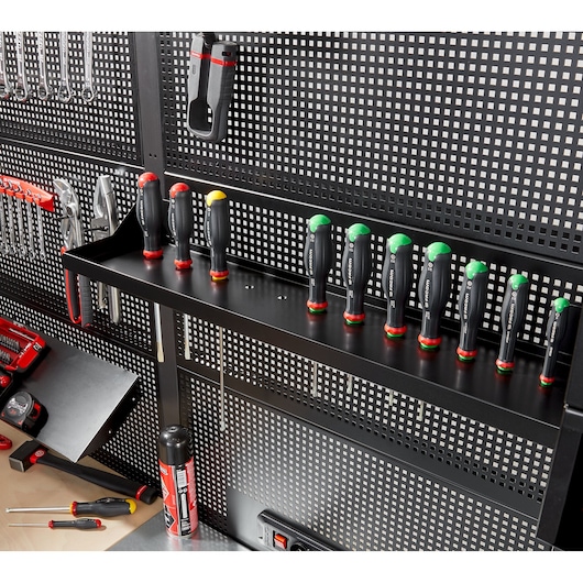 Facom RWS-SHELFBS tool shelf with multiple screwdrivers stored upright on a black perforated wall panel.