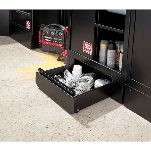 Facom RWS2-DRAWERBS black steel storage drawer open with coiled cords and rope inside, next to cabinets on workshop floor.