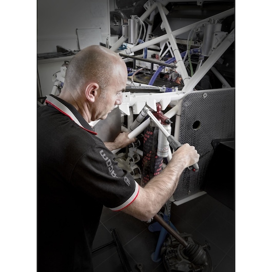 Photo of Facom S.209-100D torque wrench being used on car frame in a workshop.