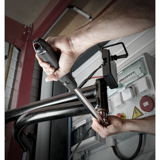 Facom S.209A200 torque wrench used on metal pipe in industrial setting.