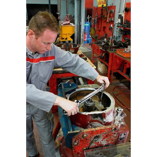 Photo of worker using Facom torque wrench S_215RC on industrial machinery in workshop.