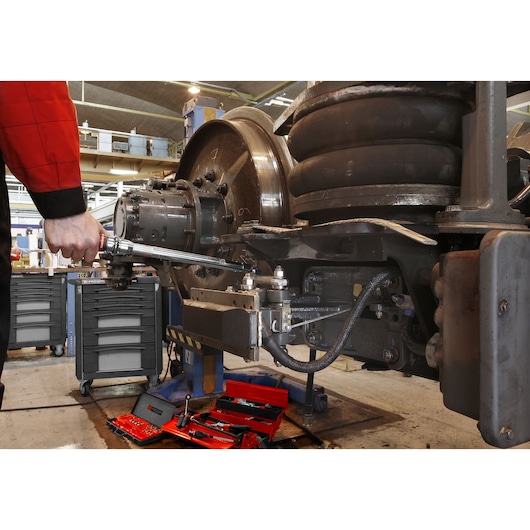 Facom S_306-350R torque wrench used on industrial machinery with red tool cases and drawers visible.