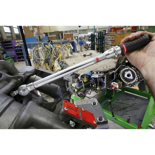 Facom S306A100 torque wrench used on machinery in workshop setting, close-up photography.