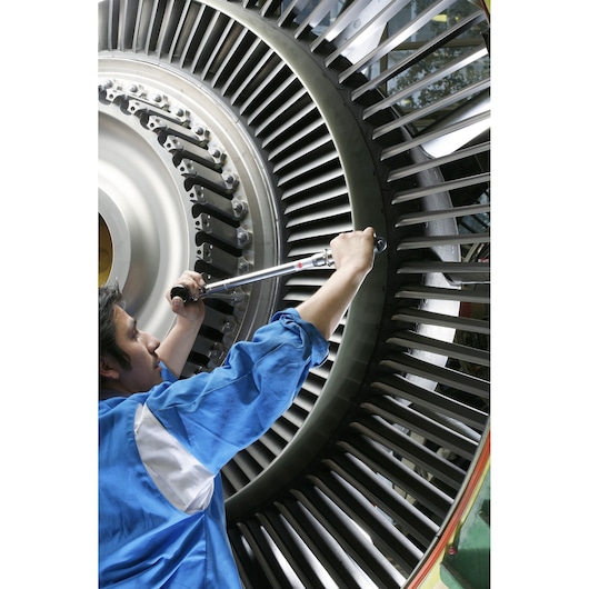 Facom S_306A350 torque wrench in use on industrial turbine, close-up side angle.