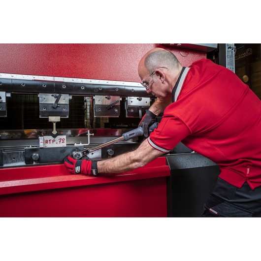 Facom torque wrench S.307-200D used by worker in red uniform adjusting industrial machine.
