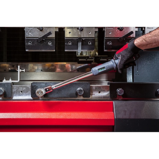 Facom S.307A200 torque wrench with digital display used on industrial machinery, close-up of tool in use.