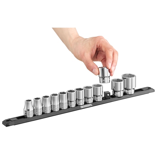 Facom S.40EGRPPB socket set with chrome sockets on black rail, hand picking up one socket, front angle.