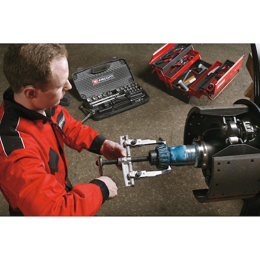 Facom U_32T15-25 tool set and red toolbox in use for automotive repair, technician in red jacket turning puller.