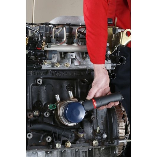 Facom U.48PB oil filter wrench held by mechanic in red uniform on car engine.