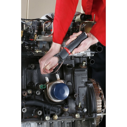 Facom U_48PL strap wrench used on car engine, close-up of tool and hand during automotive maintenance.